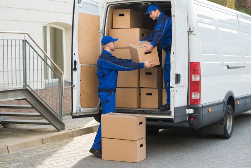 Removal team carrying furniture through a residential street in Ealing